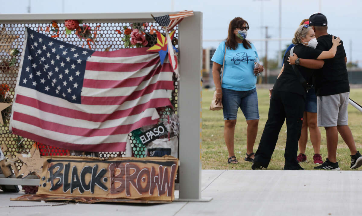 People embrace at a temporary memorial in Ponder Park honoring victims of the Walmart shooting which left 23 people dead in a racist attack on August 2, 2020, in El Paso, Texas.