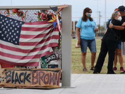 People embrace at a temporary memorial in Ponder Park honoring victims of the Walmart shooting which left 23 people dead in a racist attack on August 2, 2020, in El Paso, Texas.