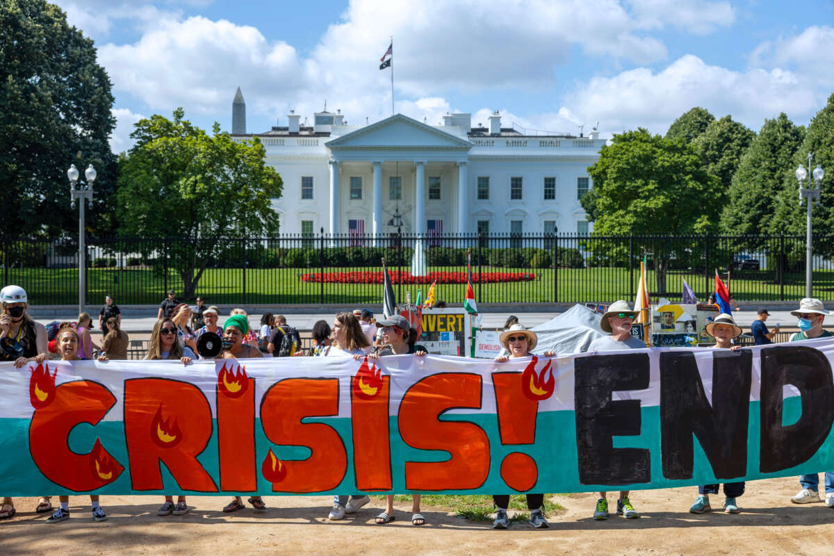 Climate activists chant as they occupy Lafayette Park with a 120 foot banner demanding President Biden act on climate change near the White House on July 4, 2023, in Washington, D.C.