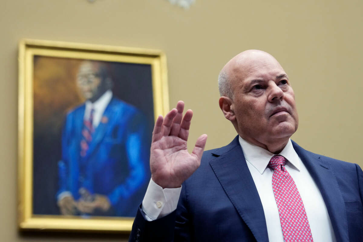 Louis DeJoy raises his hand to swear an oath