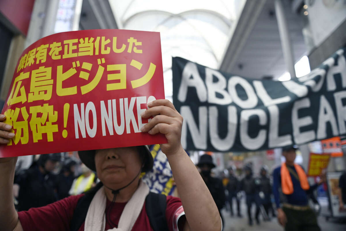 People display signs in Japanese and English calling for the cessation of nuclear armament