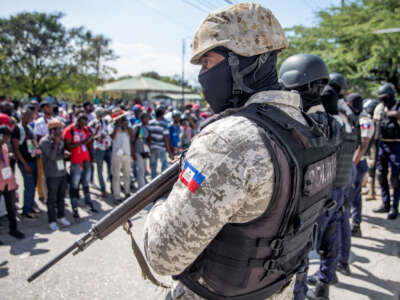 Journalists face armed police as they gather outside the Departmental Directorate of Police to file a complaint after they were targeted with tear gas while covering a protest against the Haitian president, in Port-au-Prince, on February 10, 2021.