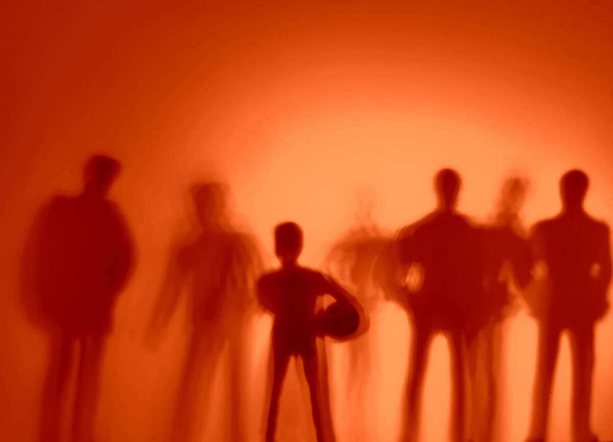 Silhouettes of young people over red