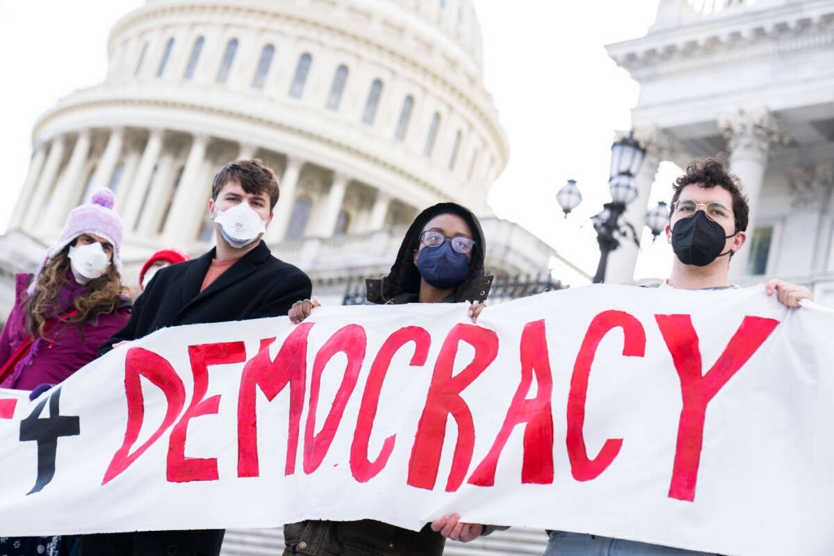 Demonstrators hold a sign at a rally outside the U.S. Capitol to urge the Senate to pass voting rights legislation, on January 19, 2022.