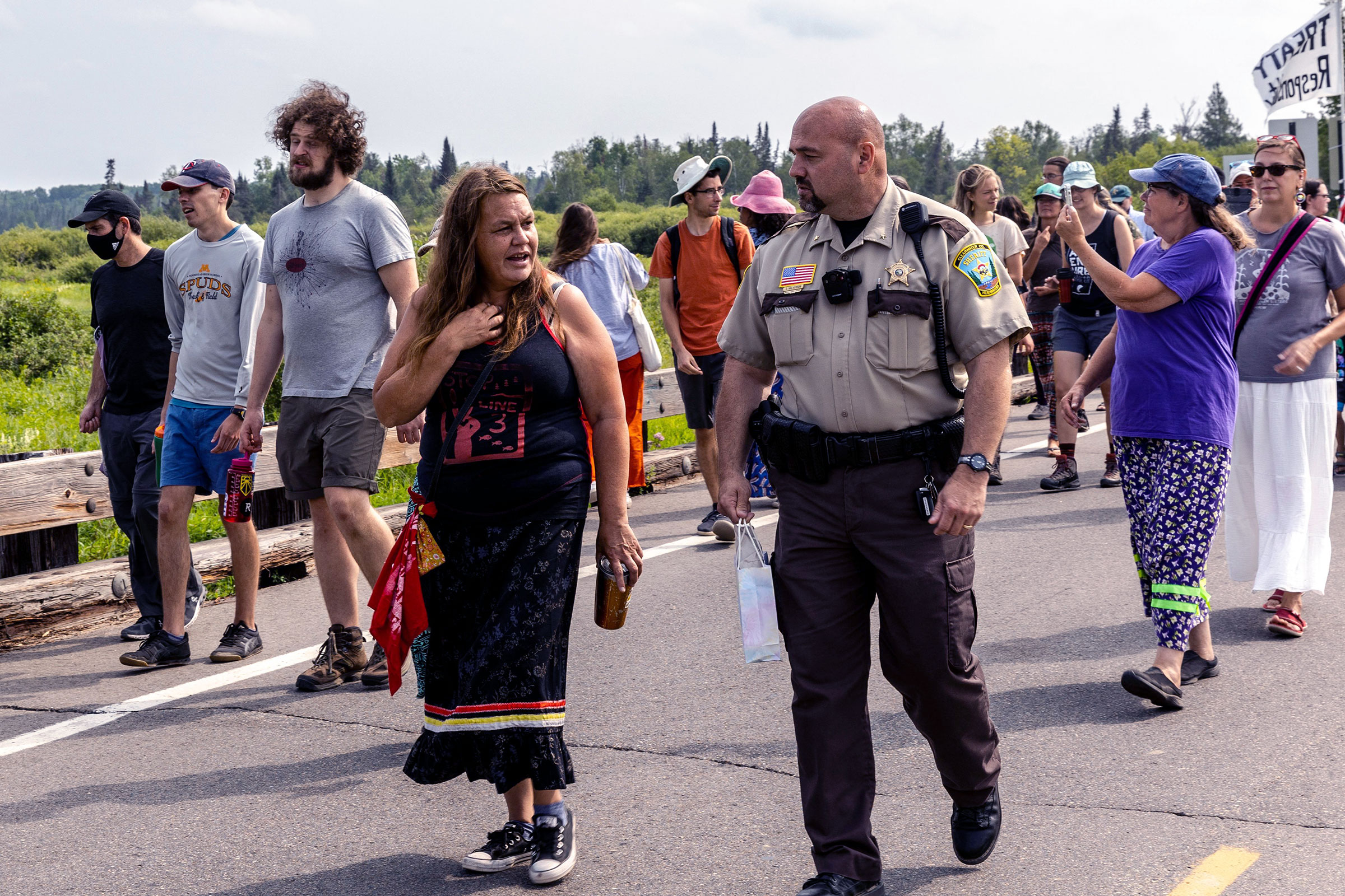 A woman speaks with a ranger as she participates in a protest on a road