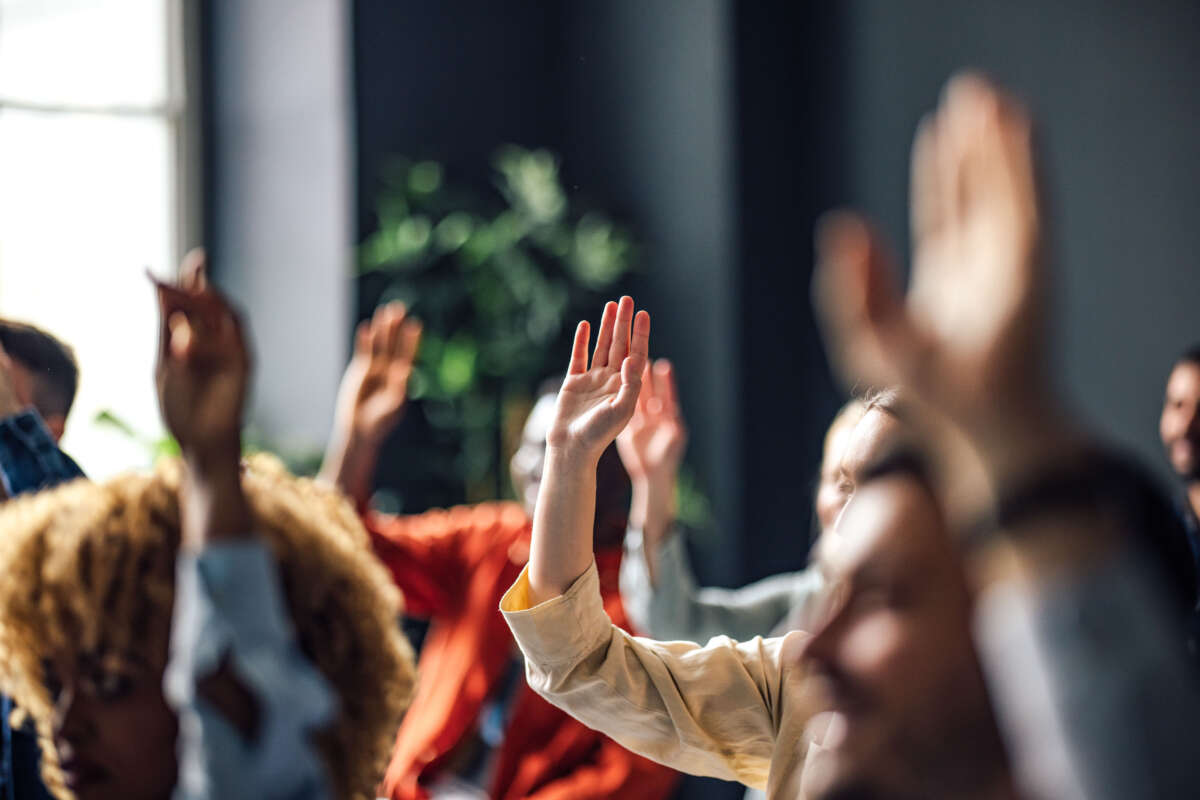 Students raise hands in class