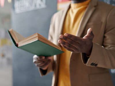 Close-up of African American teacher reading a book for students during a lecture