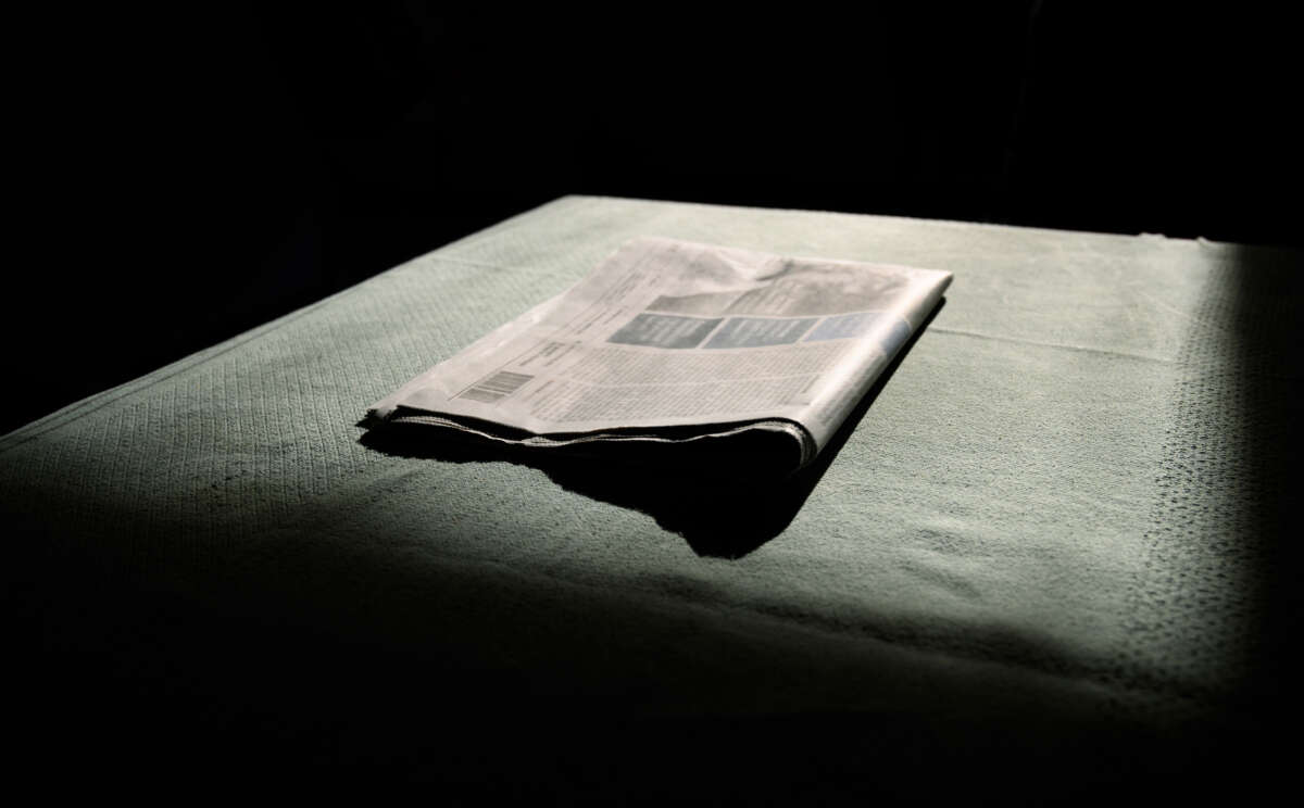 A newspaper sits in darkness