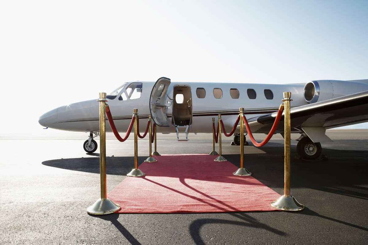 Private jet with red carpet and velvet rope