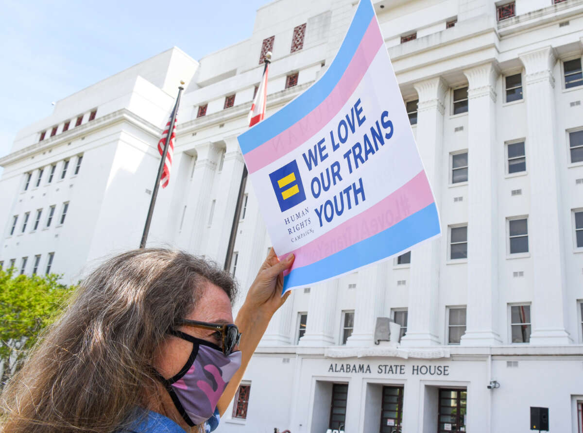 Jodi Womack holds a sign that reads 'We Love Our Trans Youth' during a rally at the Alabama State House to draw attention to anti-transgender legislation introduced in Alabama, on March 30, 2021, in Montgomery, Alabama.