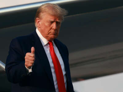 Former President Donald Trump gives a thumbs up as he arrives at Atlanta Hartsfield-Jackson International Airport on August 24, 2023, in Atlanta, Georgia.