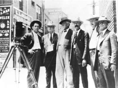 Members of a vigilance committee stand watch in suits.