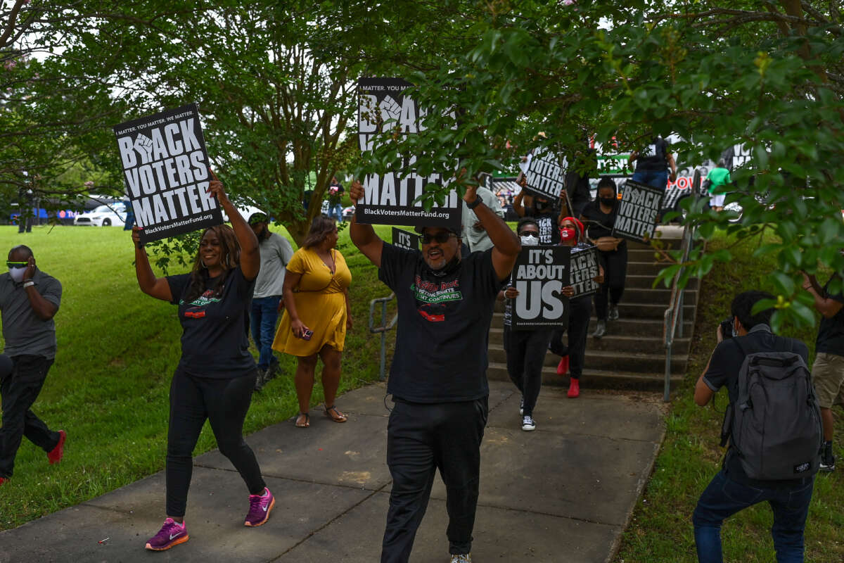 Protesters lead a group of people to an entrance at Tougaloo College during a Black Voters Matter event on June 19, 2021, in Jackson, Mississippi.