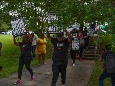 Protesters lead a group of people to an entrance at Tougaloo College during a Black Voters Matter event on June 19, 2021, in Jackson, Mississippi.