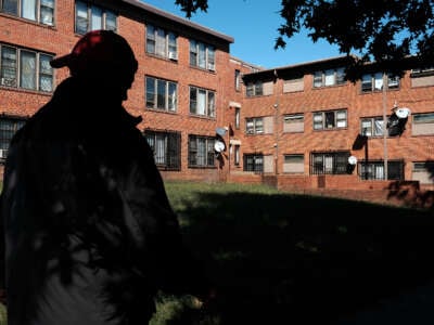 A person stands in front of several boarded up public housing units in the Lincoln Heights area in Washington, D.C., on September 23, 2022.