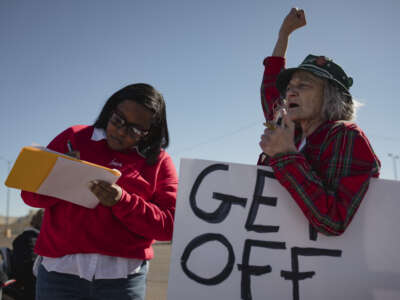 A person signs a petition to put abortion access to a ballot measure as another person holds her fist in the air during a pro-choice rally held by Eastern New Mexico Rising in Clovis, New Mexico, on January 22, 2022.