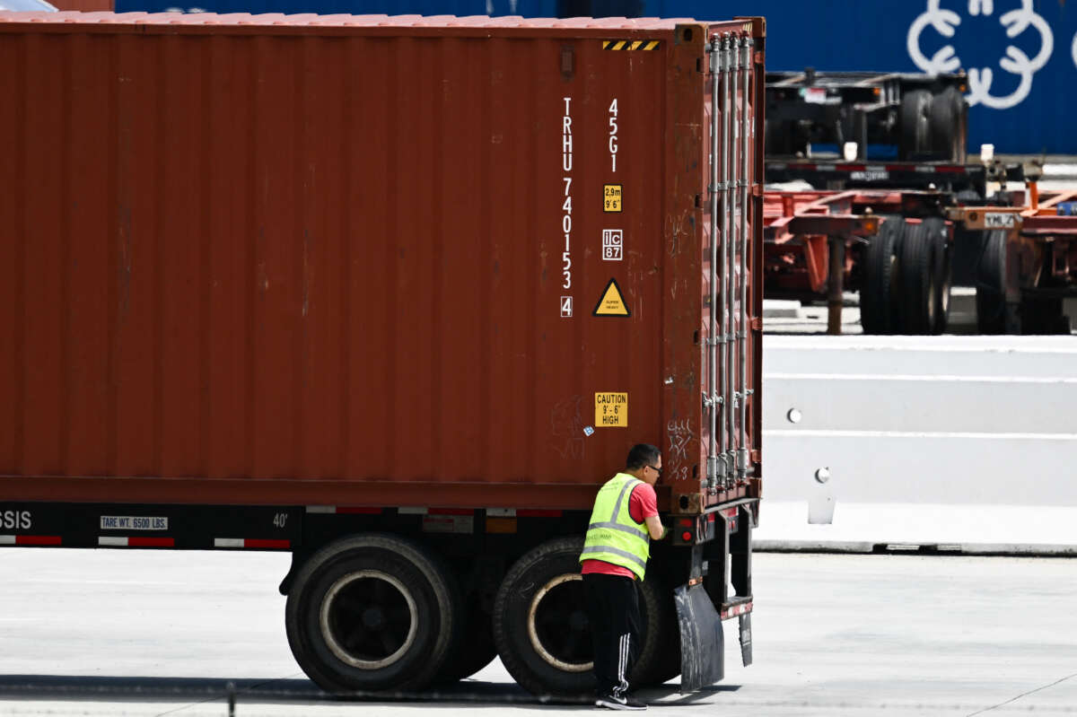 A truck driver inspects a cargo shipping container before departing the Port of Los Angeles in Los Angeles, California on June 7, 2023.