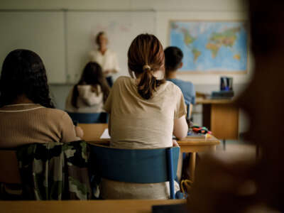 Teenage girl sitting at desk in high school classroom