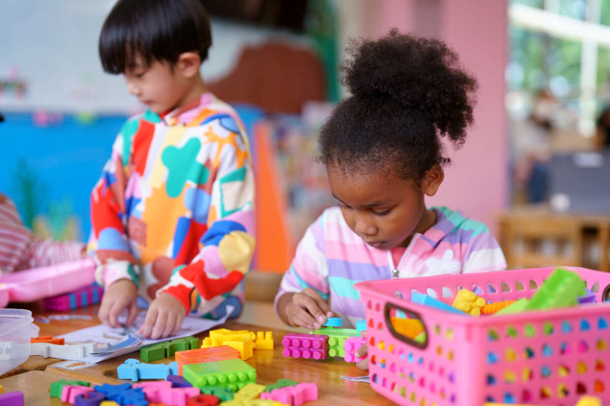 Pre-school aged children play with blocks in a playroom