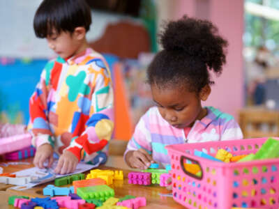 Pre-school aged children play with blocks in a playroom