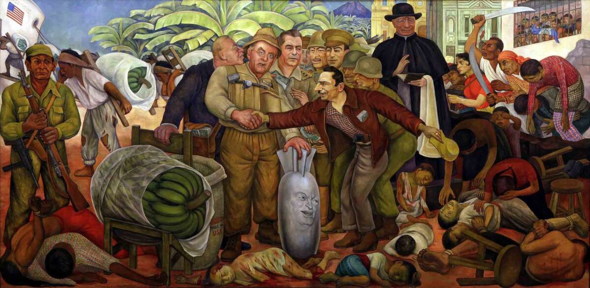 Glorious Victory, by Diego Rivera, depicting the 1954 U.S. coup that ousted the government of President Jacobo Arbenz Guzman. In the foreground, Central Intelligence Agency Director Allen Dulles shakes hand of U.S.-selected coup “leader” Col. Castillo Armas. Dulles’s hand rests on bomb with face of President Dwight Eisenhower. Behind Dulles, his brother, State Department head John Foster Dulles, and Ambassador to Guatemala John Peurifoy, hand cash to Guatemalan military commanders. A Catholic priest officiates over slaughter of Mayan and other poor Guatemalans. Exploited workers carry United Fruit Company bananas.