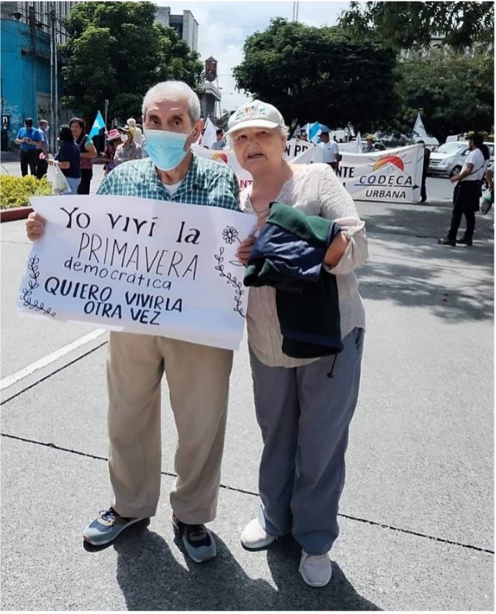Una pareja sostiene un cartel en una protesta en Guatemala que dice: Viví la PRIMAVERA democrática.  Quiero volver a vivirlo.