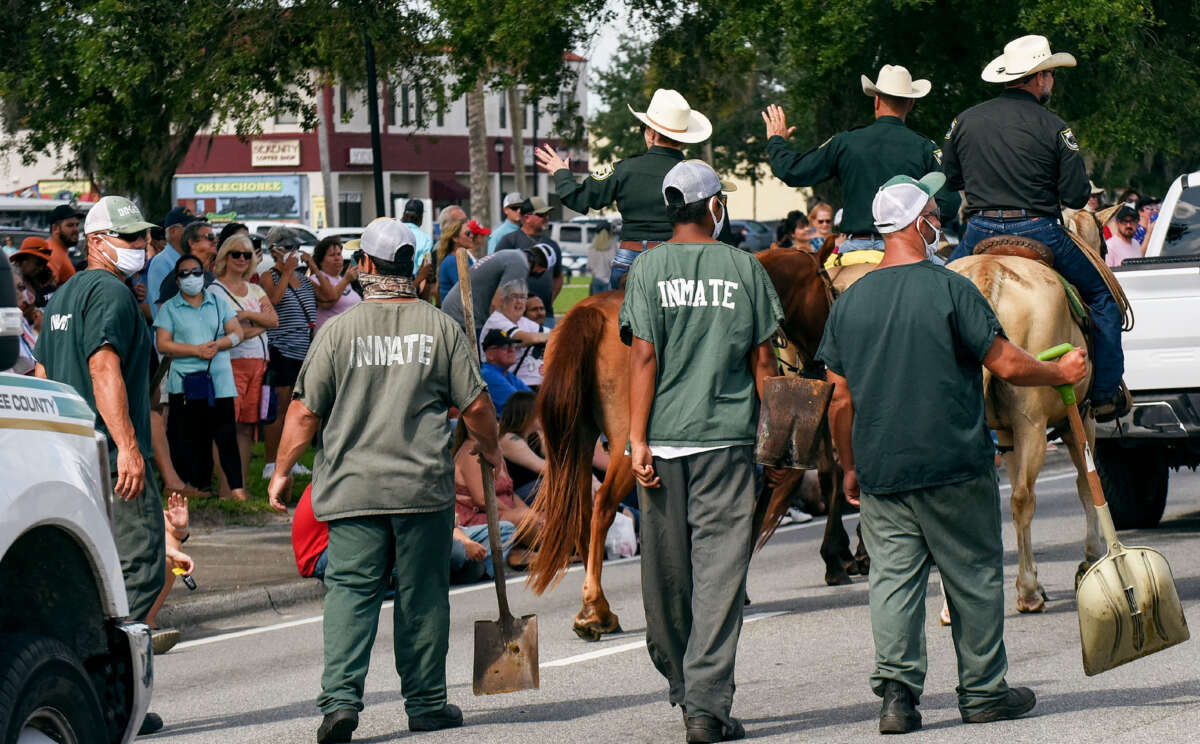 Incarcerated workers clean up after the police horses at the annual Labor Day parade in Okeechobee, Florida, on September 6, 2021.