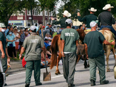 Incarcerated workers clean up after the police horses at the annual Labor Day parade in Okeechobee, Florida, on September 6, 2021.