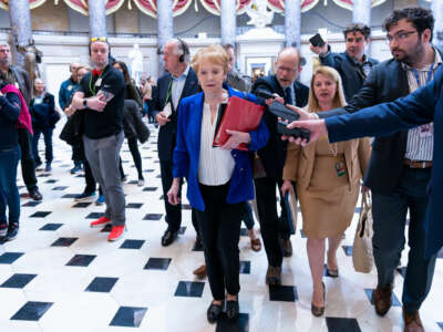 Rep. Kay Granger is interviewed by journalists holding out recording devices as she walks