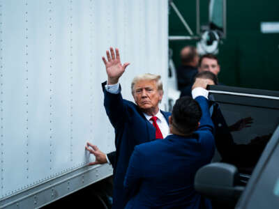 Donald Trump waves while entering a car