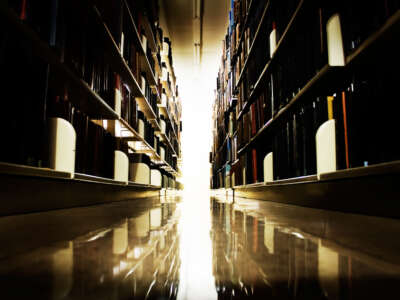 Library bookshelves, dark aisle leading to light