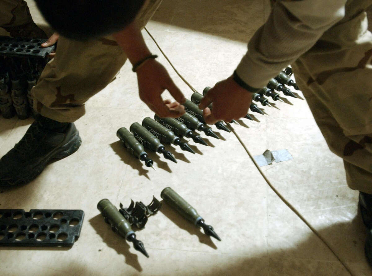 U.S. Army Spcl. Sergio Cardenas stands over 25mm rounds of depleted uranium ammunition on February 2004, at a base in Tikrit, approximately 110 miles north of Baghdad.