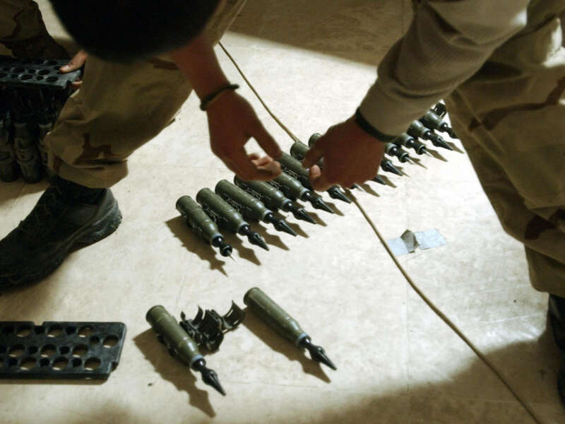 U.S. Army Spcl. Sergio Cardenas stands over 25mm rounds of depleted uranium ammunition on February 2004, at a base in Tikrit, approximately 110 miles north of Baghdad.