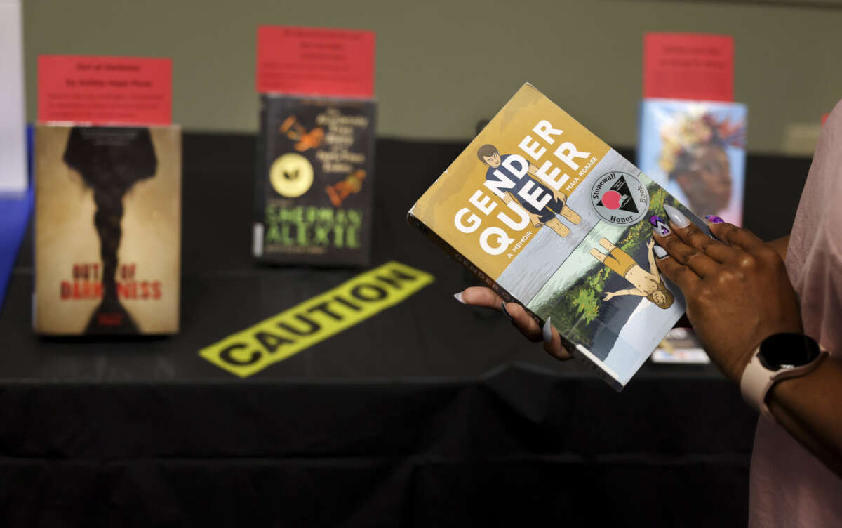 "Gender Queer" by Maia Kobabe is held as a selection of banned and challenged books are seen during Banned Books Week 2022, at the Lincoln Belmont branch of the Chicago Public Library on Thursday, Sept. 22, 2022.