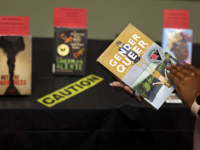"Gender Queer" by Maia Kobabe is held as a selection of banned and challenged books are seen during Banned Books Week 2022, at the Lincoln Belmont branch of the Chicago Public Library on Thursday, Sept. 22, 2022.