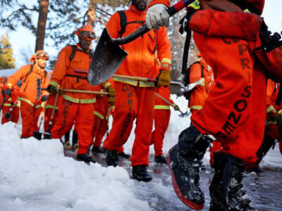 A crew of incarcerated firefighters walk back to their vehicle after shoveling and clearing snow after a series of winter storms in the San Bernardino Mountains in southern California on March 3, 2023, in Crestline, California.