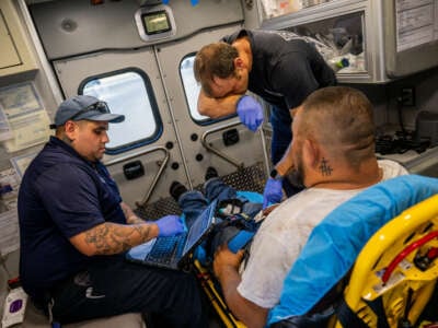 Emergency Medical Technicians William Dorsey and Omar Amezcua assist a person after he called in for chest pain during a heatwave on June 29, 2023 in Eagle Pass, Texas.