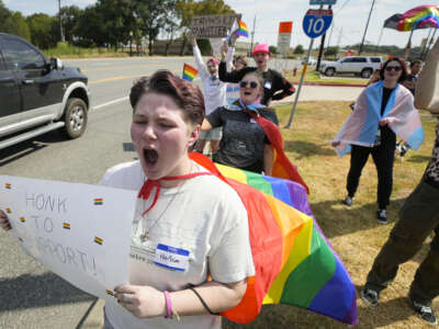 Max Newell, left, joins student demonstrators as they protest against Katy ISD's new transgender policy outside the school district's educational support complex on August 30, 2023 in Katy, Texas.