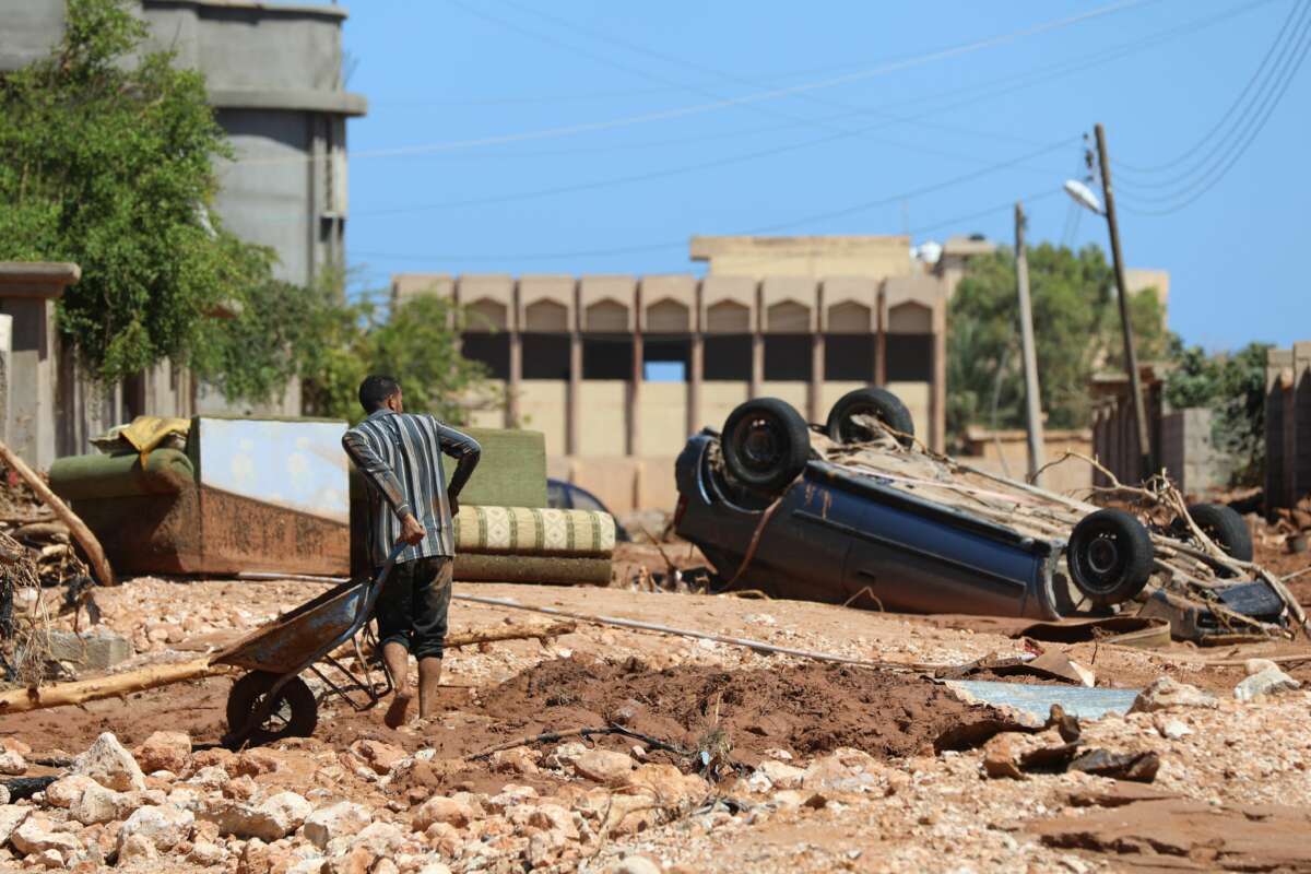 A man crosses a rubble-filled street in Libya's eastern city of Soussa