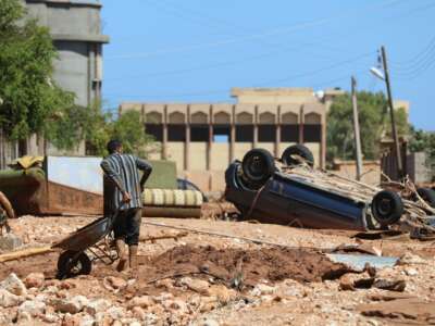 A man crosses a rubble-filled street in Libya's eastern city of Soussa