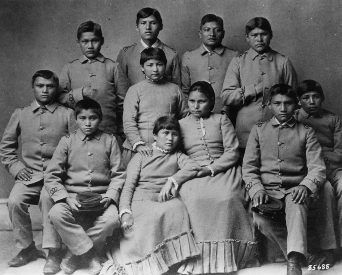 Black and white photo of Chiracahua Apache children wearing school uniforms at the Carlisle Indian school