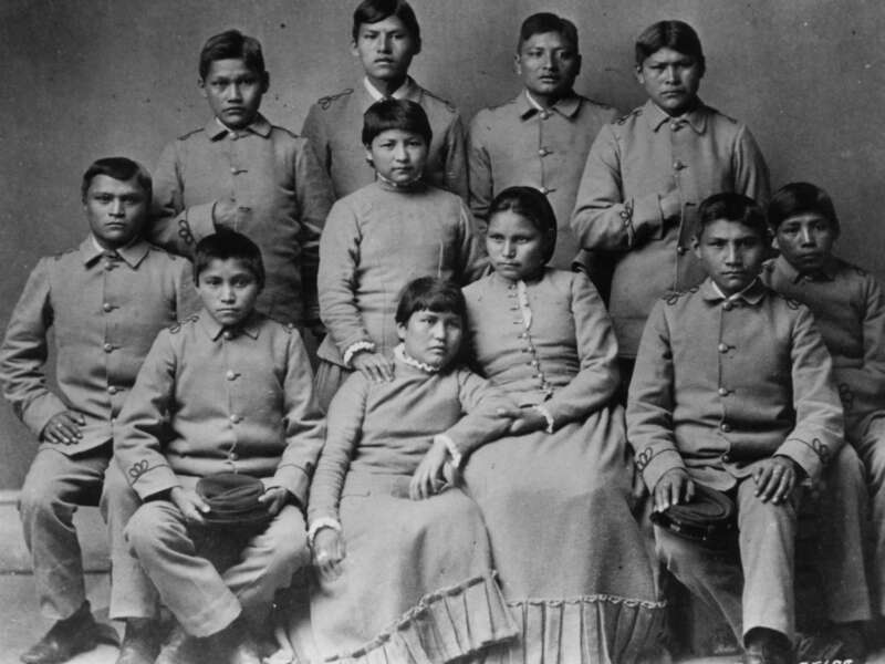 Black and white photo of Chiracahua Apache children wearing school uniforms at the Carlisle Indian school