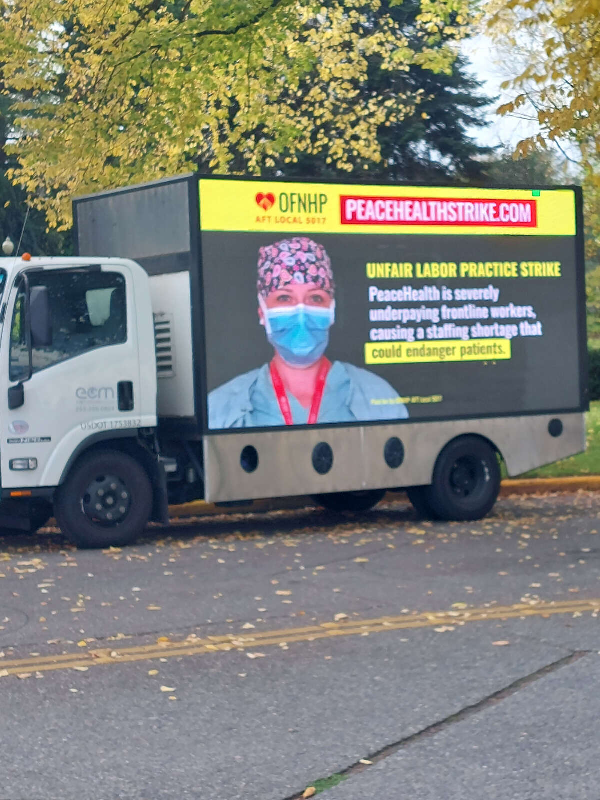 A truck with a screen promoting the unfair labor practice strike by health care workers with PeaceHealth.