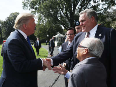 Then-President Donald Trump shakes hands with Charles P. Rettig, commissioner of Internal Revenue Service, before departing from the White House on October 2, 2018, in Washington, D.C.