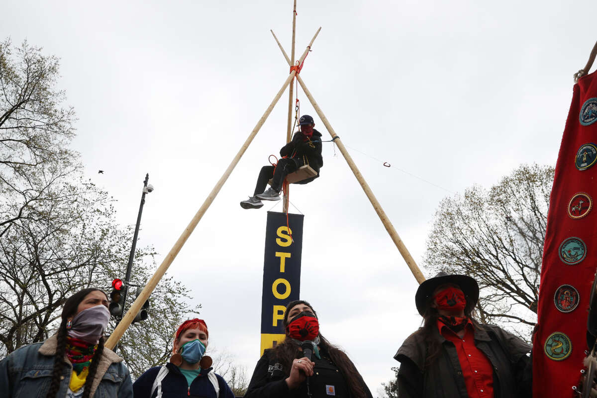 Indigenous environmental activists sing the Warrior Woman Song in front of a large tripod built to block traffic near Black Lives Matter Plaza on the north side of the White House as part of a protest against oil pipelines on April 1, 2021, in Washington, D.C.