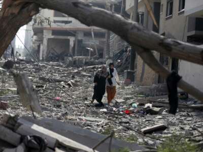 People walk through the rubble that was once their homes