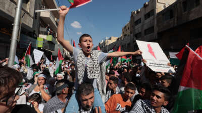 Jordanian protesters march at the downtown in front of the Husseini Mosque, raising the Jordanian and Palestinian flags, demanding an end to the Israeli aggression on the Gaza Strip and the protection of civilians, on October 13, 2023, in Amman, Jordan.