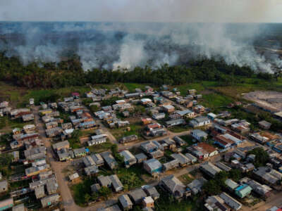 The smoke from a fire in a forest area approaches houses at the Cacau Pirera District in Iranduba, Amazonas state, Brazil, on September 25, 2023.