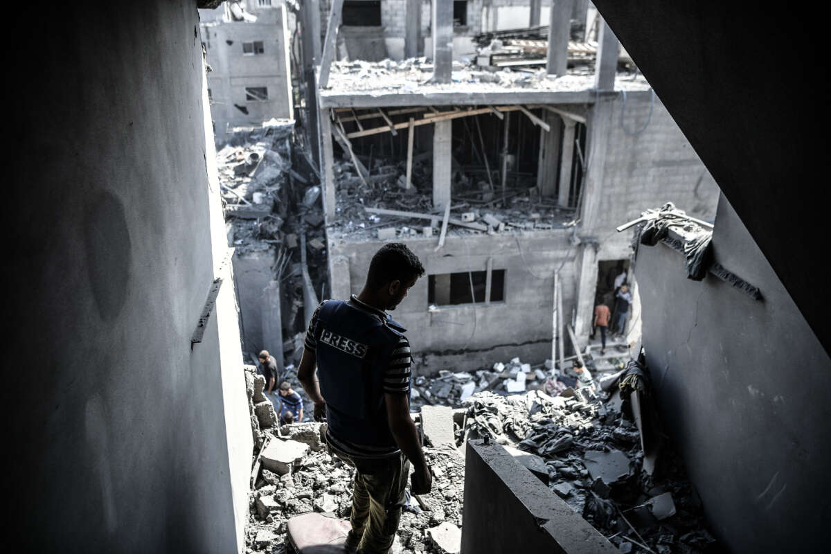 A member of the press is seen among the destroyed buildings and debris after the Israeli airstrikes that has been going on for five days in Khan Yunis, Gaza, on October 11, 2023.