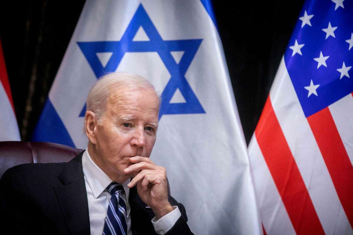 Joe Biden sits in front of the Israeli flag during a meeting